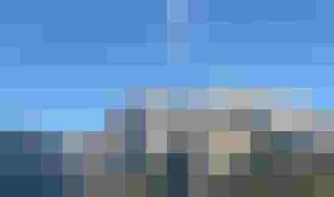 Grüne Almwiese mit Blick auf das Hochkönigmassiv und blauen Himmel