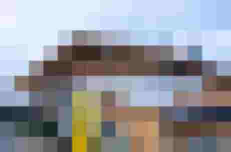 Almhütte Hochmaisalm mit gelbem Wanderschild und Autos im Salzburger Land