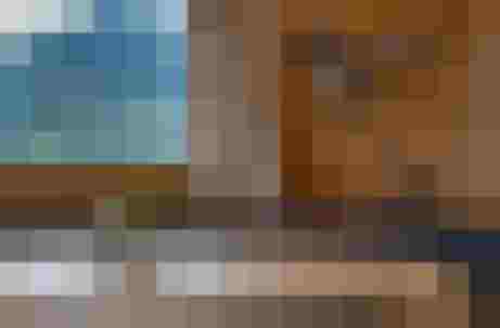 Gemütliche Almstube mit Holzwänden, Bergblick, runder Sitzbank und Kerzen auf Tisch