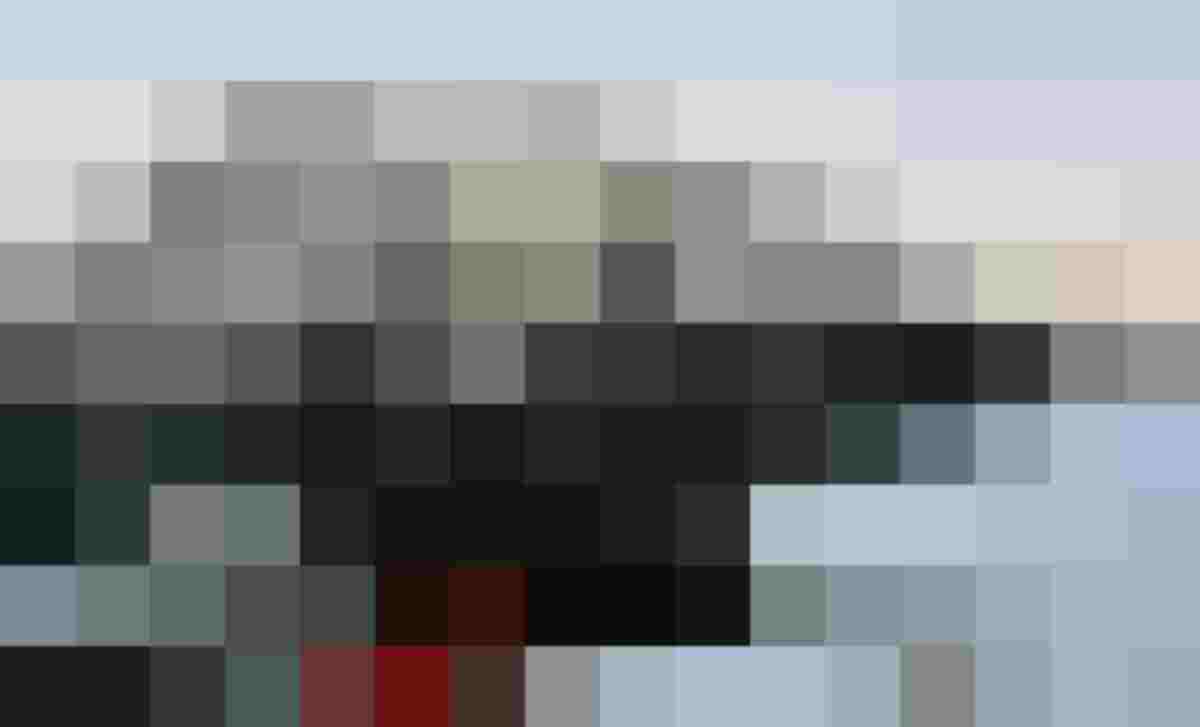 Pistenraupe vor verschneiter Hütte mit Bergpanorama