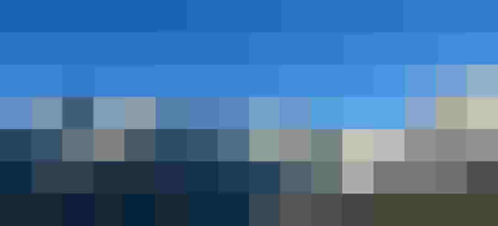 Verschneites Bergpanorama mit steilen Felswänden unter klarem blauem Himmel